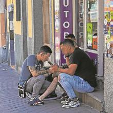 Habituales del barrio, sentados en un locutorio
